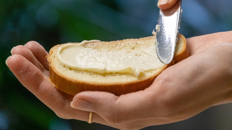 hands buttering bread