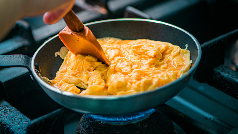 Cooking scrambled eggs in a pan with spatula