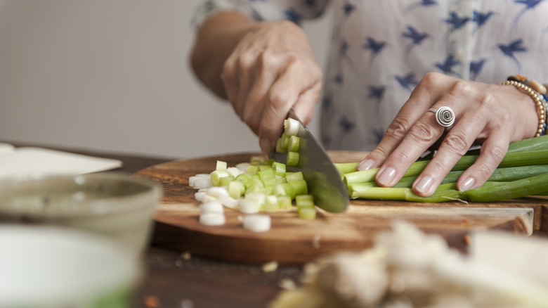 woman chopping scallions