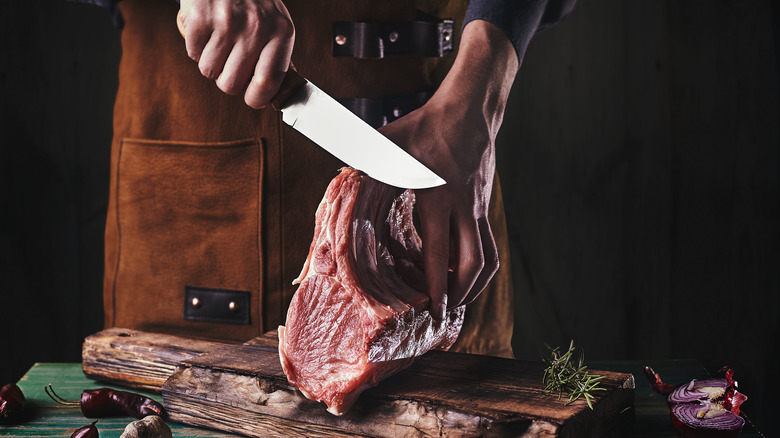 butcher slicing raw meat