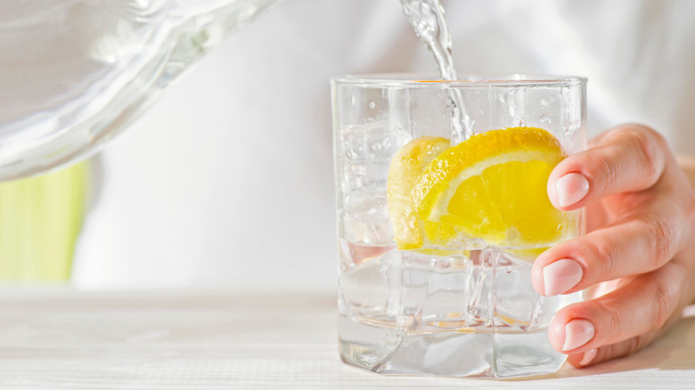 pouring water over lemon