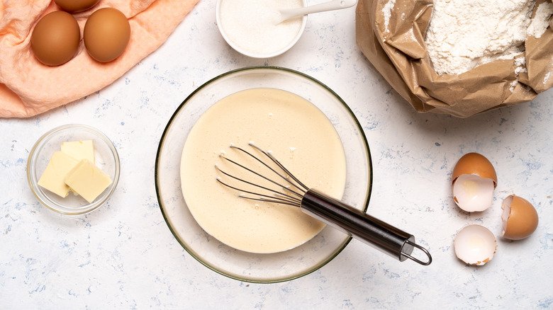 Cake batter in a bowl, surrounded by ingredients 