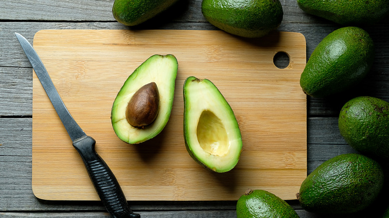 Ripe green avocado cut open with pit