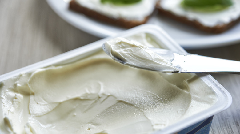 knife in container of cream cheese