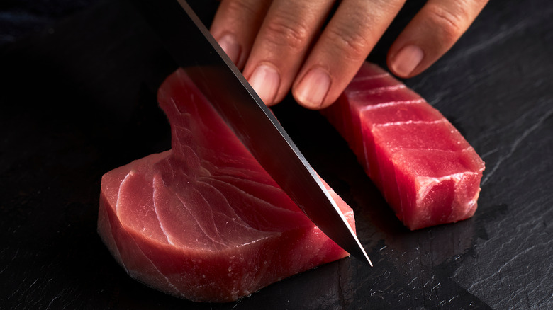 Person slicing raw tuna