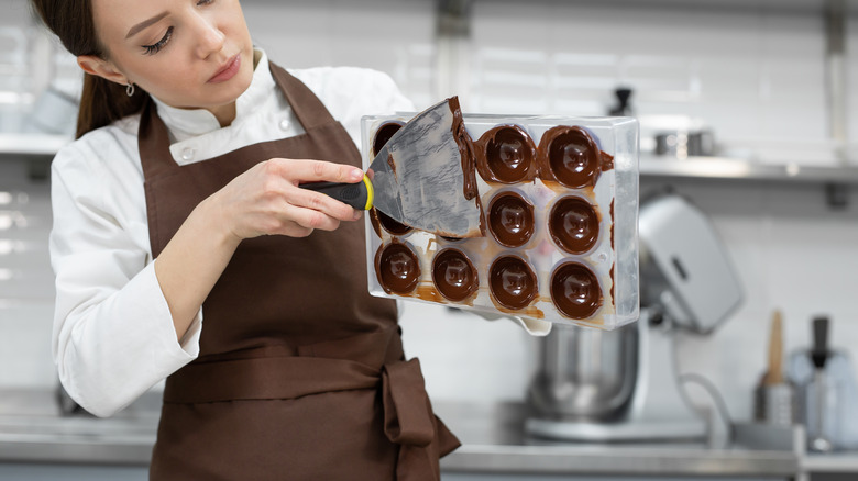 chocolatier working with chocolate molds 