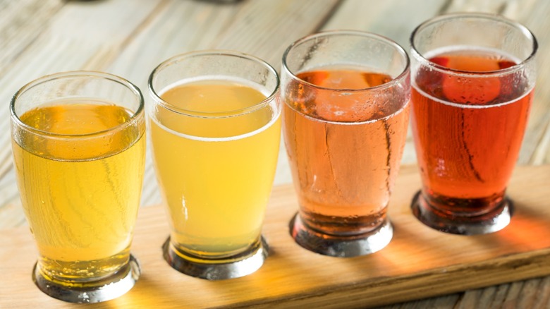 A flight of four colorful ciders