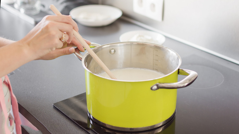 woman stirring cream sauce in pot