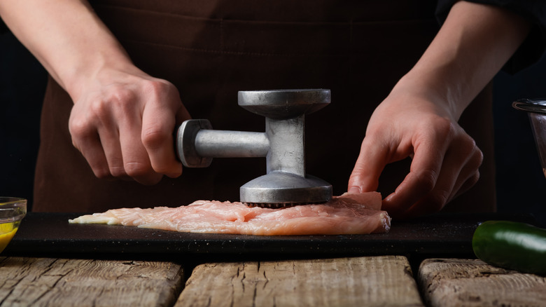 Pounding chicken thin with a meat mallet