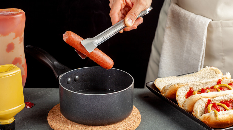 Hot dog being removed from pot.