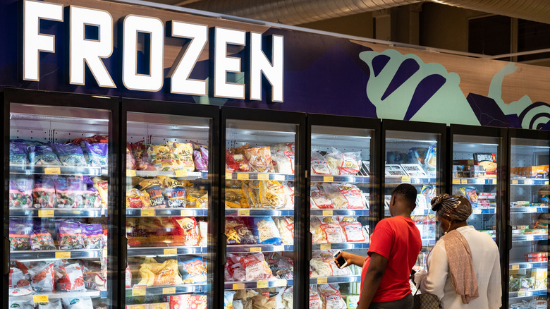 Couple standing in front of frozen food aisle