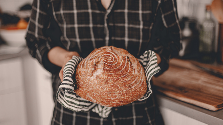 Baker holding a loaf of homemade bread