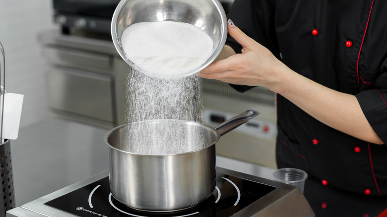 pouring sugar in saucepan