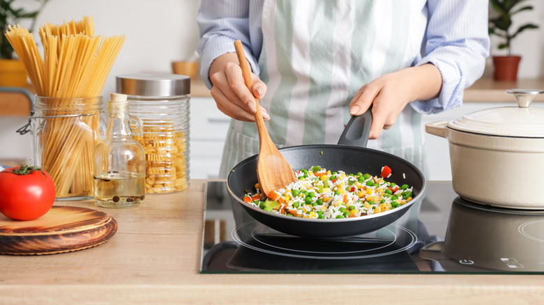 Person cooking with wooden spoon