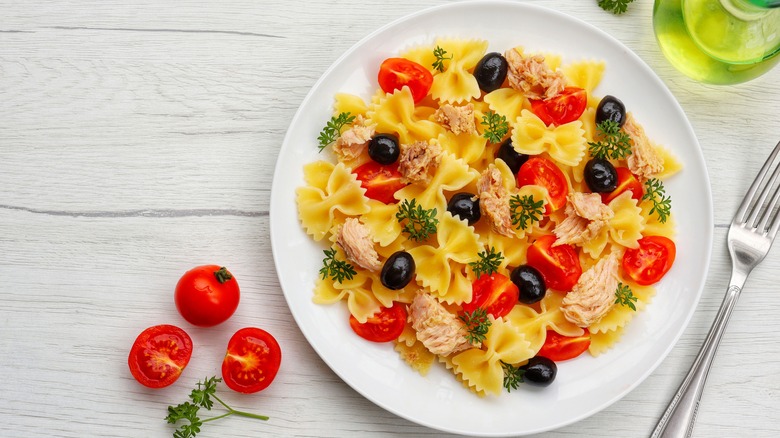 Plate of plain farfalle pasta salad over white wood