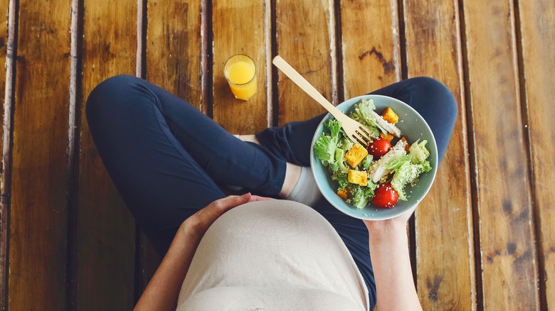 Pregnant woman with salad and orange juice