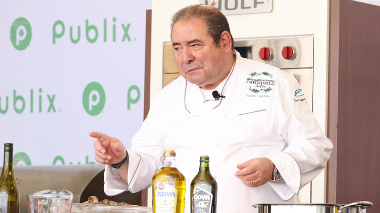 Emeril Lagasse points in white chef uniform