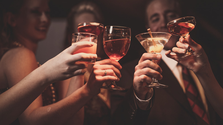 people toasting with various cocktails