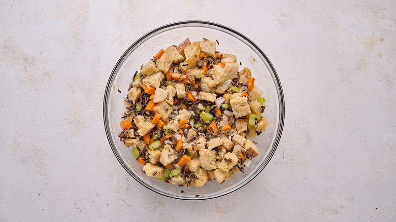 tossing stuffing together in bowl