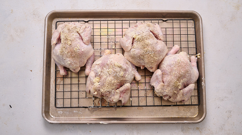 seasoning cornish hens on sheet tray