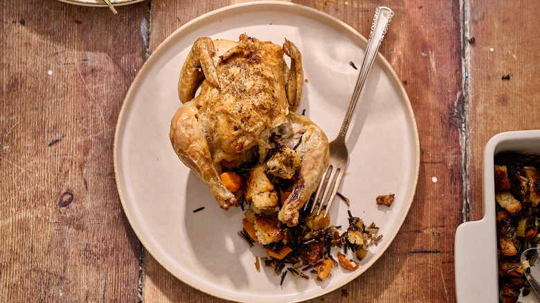 cornish hen on plate with stuffing