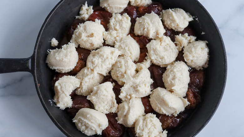 dough balls on plums in skillet