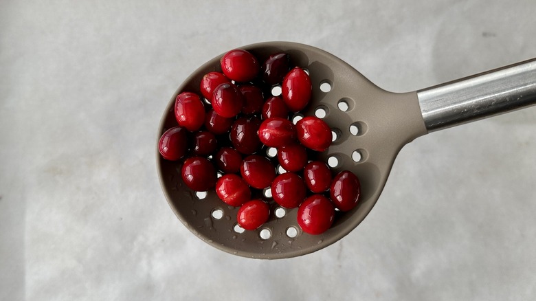 candied cranberries in slotted spoon