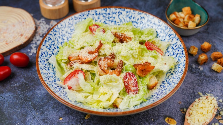 Caesar salad with scattered tomatoes, spoon, croutons