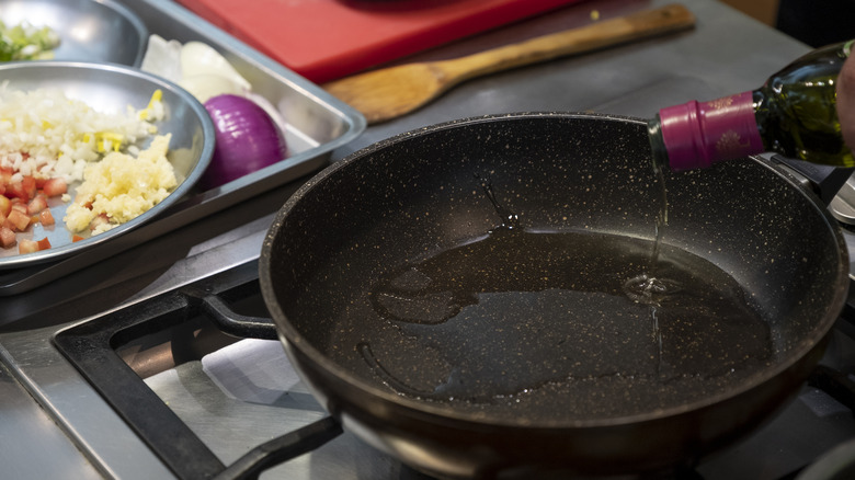 pouring oil into cast iron skillet