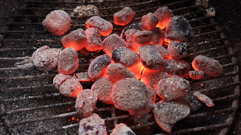 Charcoal briquettes glowing on grill