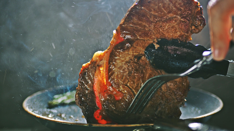 Searing ribeye steak in pan