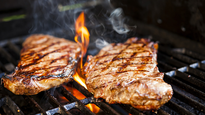 Grilling steak over flame