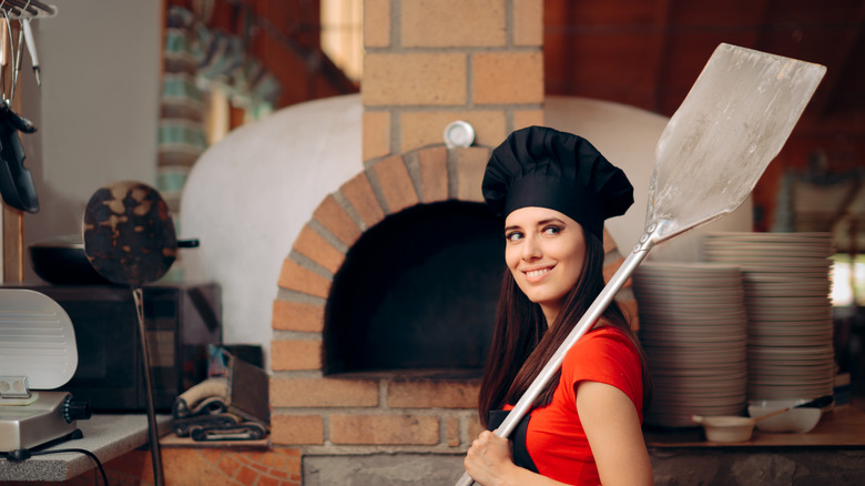 Woman holding a metal pizza peel