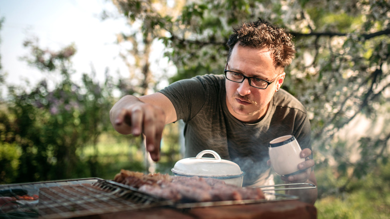 Home cook grilling burgers outside