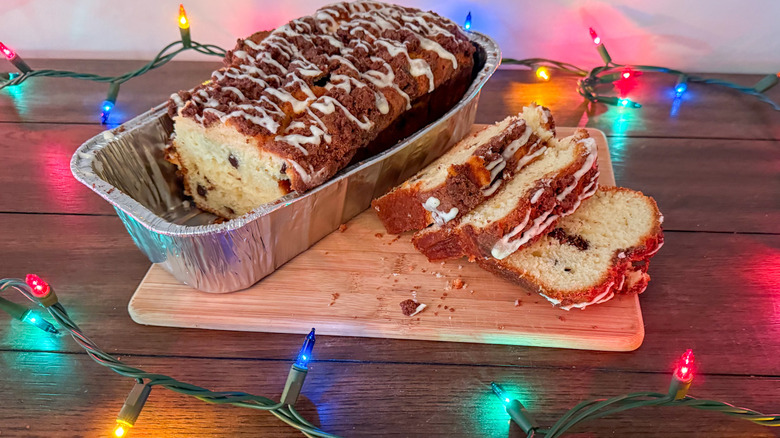 Pound cake in a loaf tin on a wooden table surrounded by Christmas lights