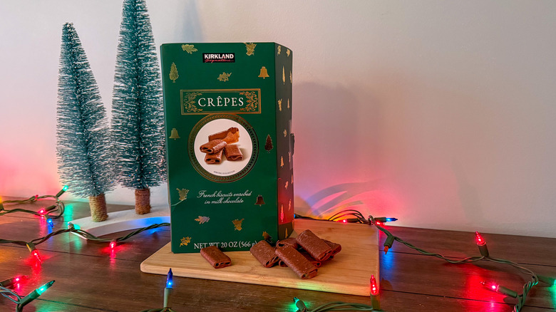 Green box of cookies on a wooden cutting board with decorations