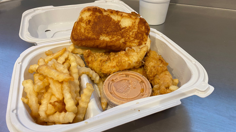 Raising Cane's box combo with fries, toast, chicken fingers, and Cane's sauce.