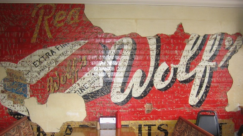 Aging wall with red, white, and gold logo that reads, "Wolf's/Bread at its Best".
