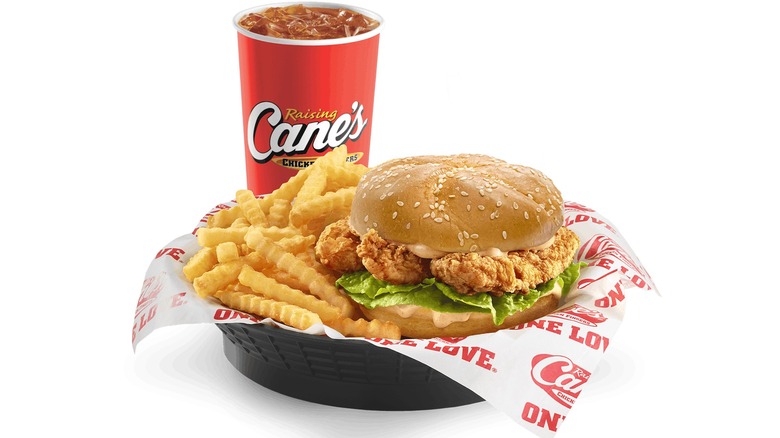 Raising Cane's chicken fingers between two slices of Texas toast covered in sauce, fries, and coleslaw.