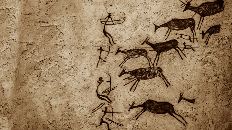 Cave painting of animals and hunters