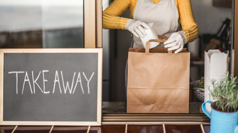 woman holding bag of take out food