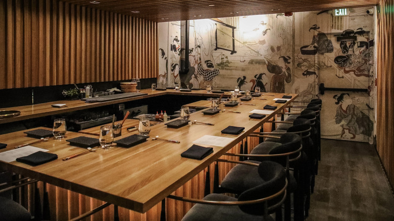 The chef's counter at Ukiyo, featuring a modern aesthetic and Japanese mural
