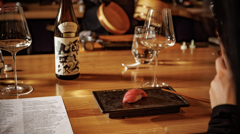 Person taking a photo of an omakase course at Ukiyo