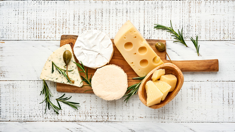 A wooden board with a few cheeses