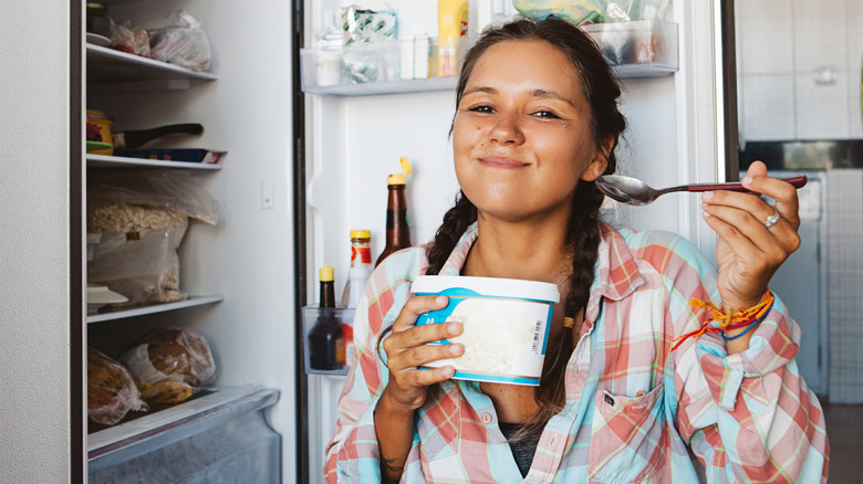 smiling woman with ice cream tub