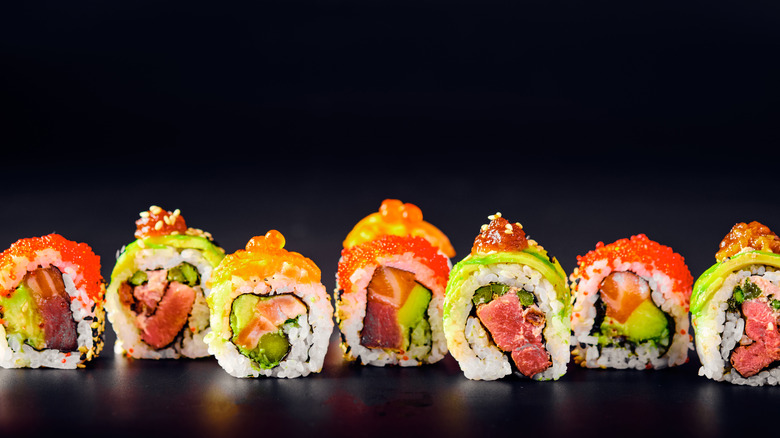 Different sushi rolls black background 