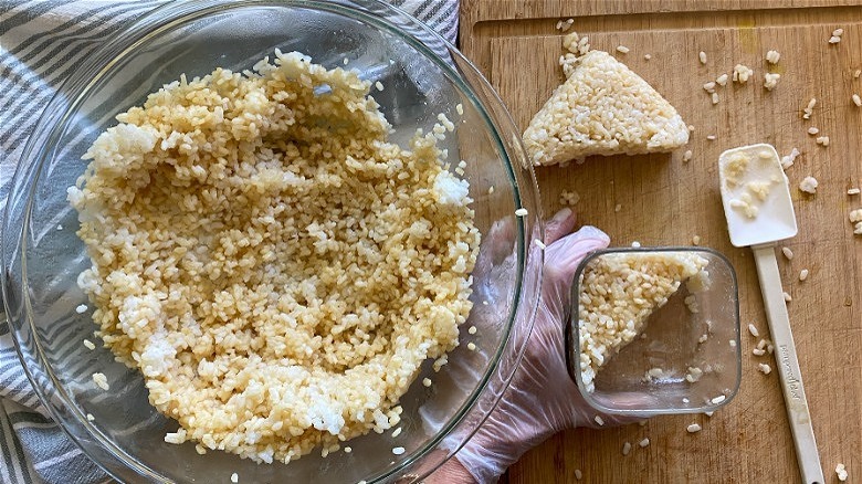 rice being shaped into triangles