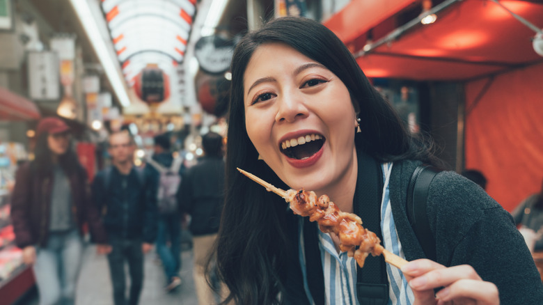 festival goer enjoying yakitori in food hall