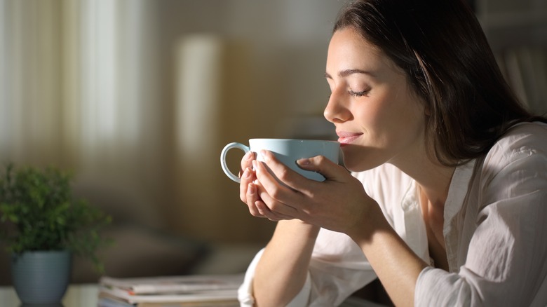 Woman about to taste her tea