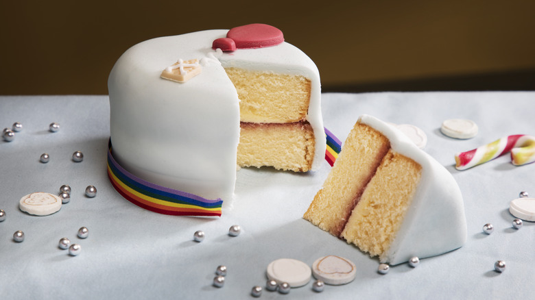 A fondant cake with rainbow border cut in half